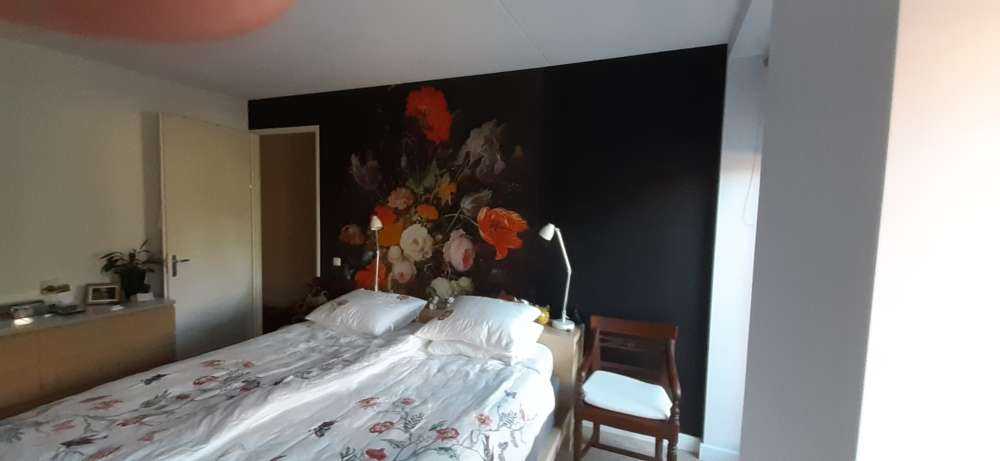Stilleben med blomster og en klokke