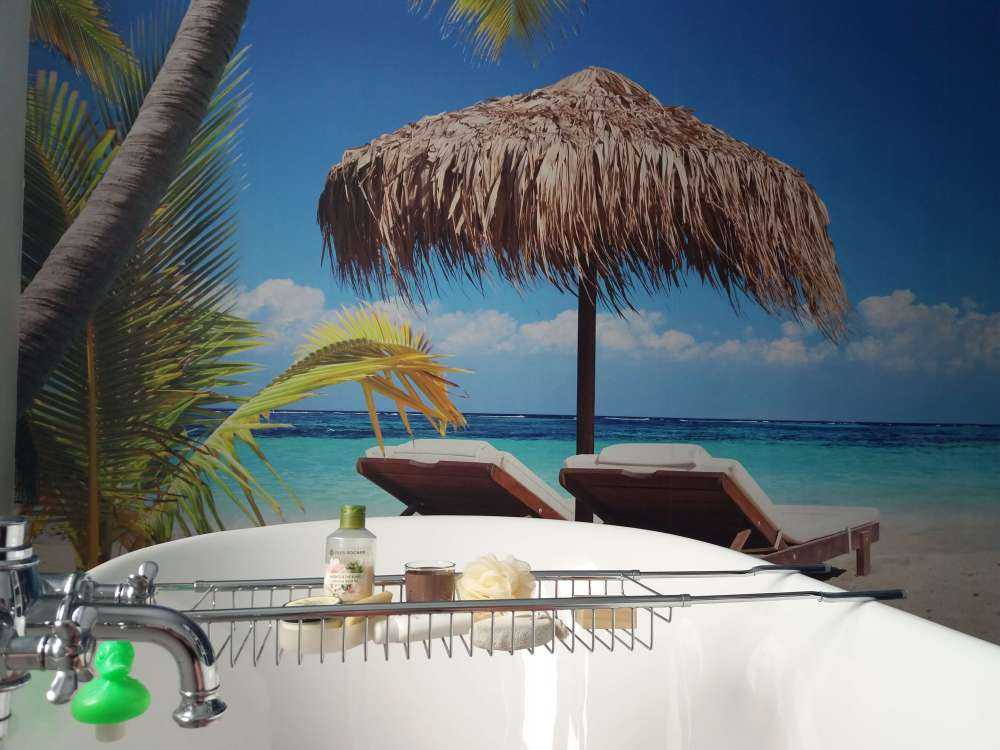 Stoler og parasoll på tropisk strand