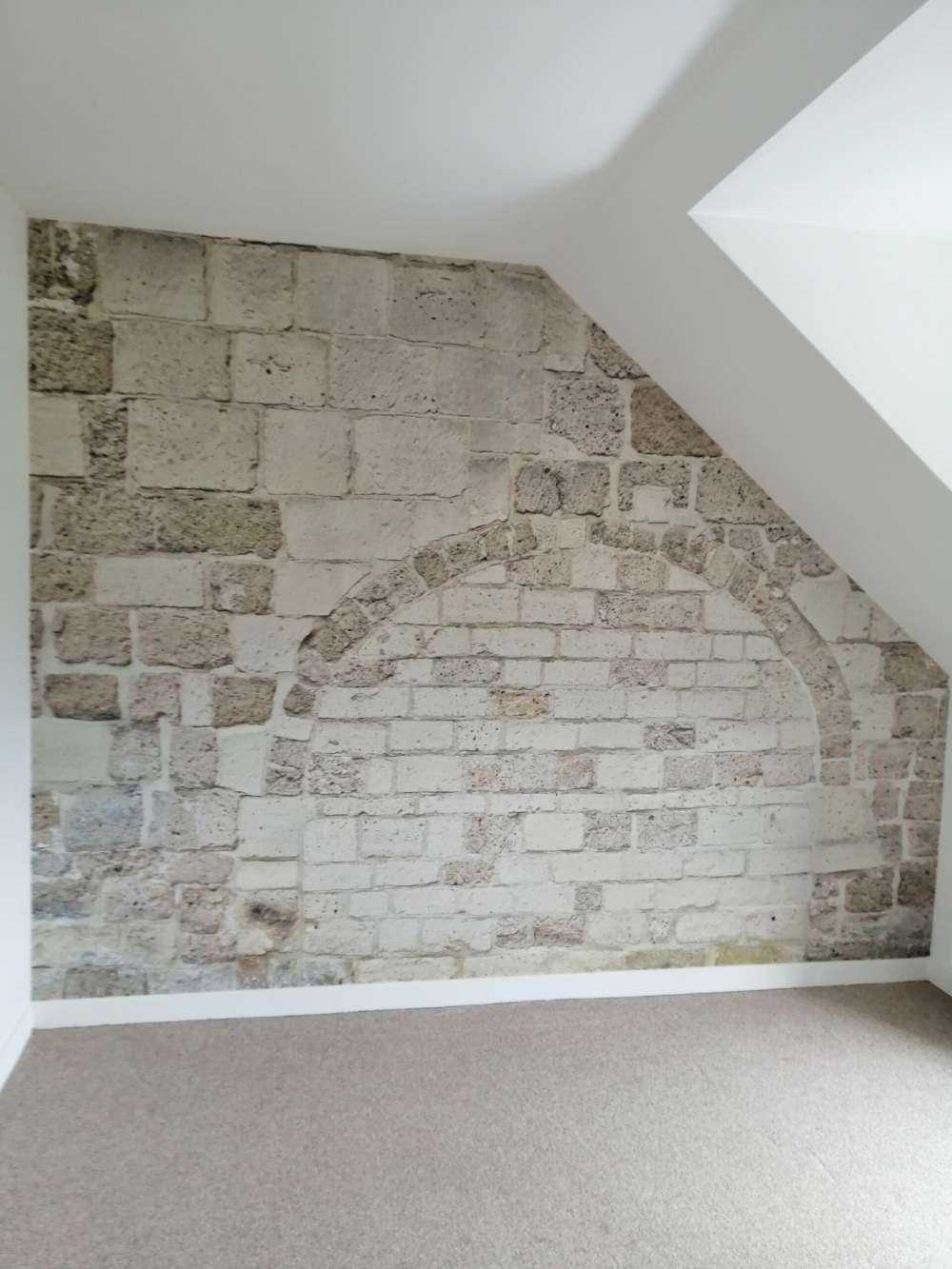 Gammel steinvegg med bue