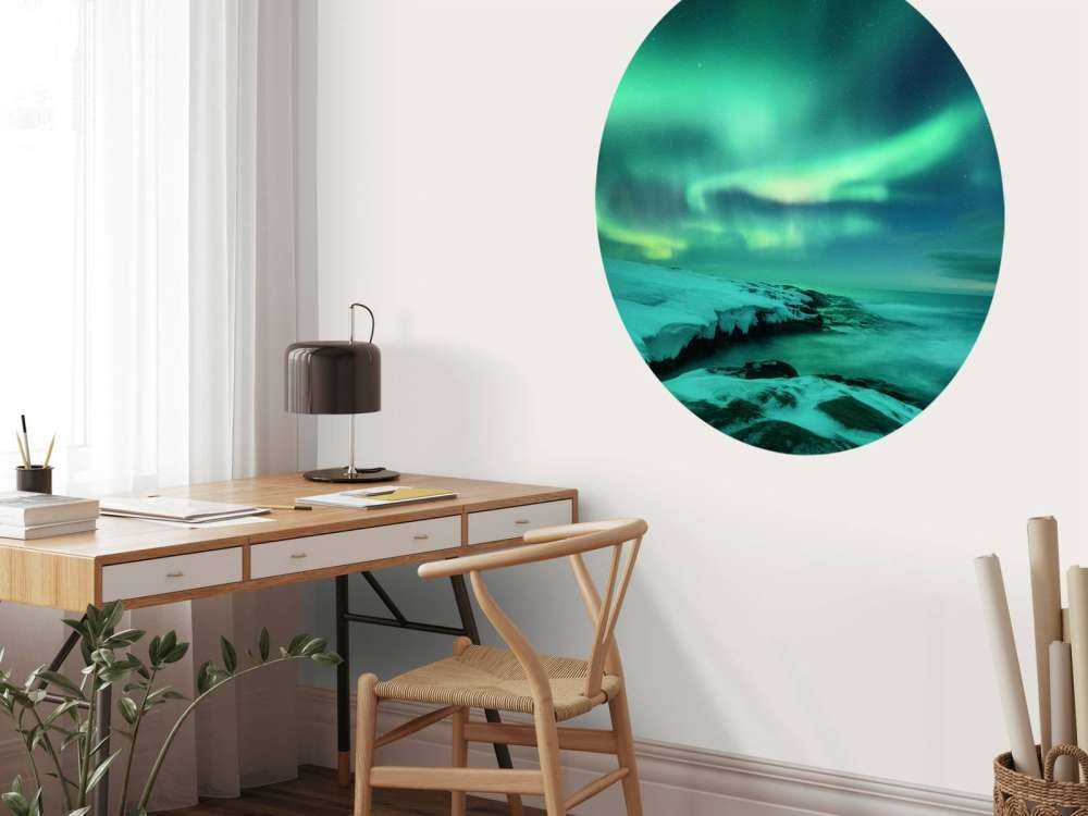 Grønt nordlys over snedækkede klipper