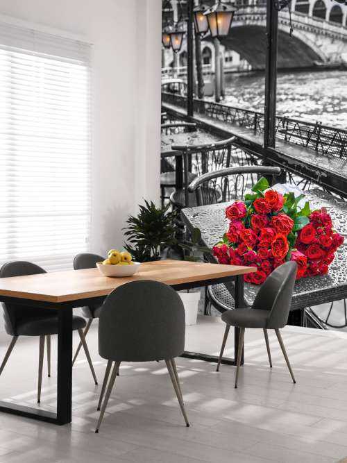 Bunch of red roses on street cafe table, Rialto Bridge, Venice, Italy
