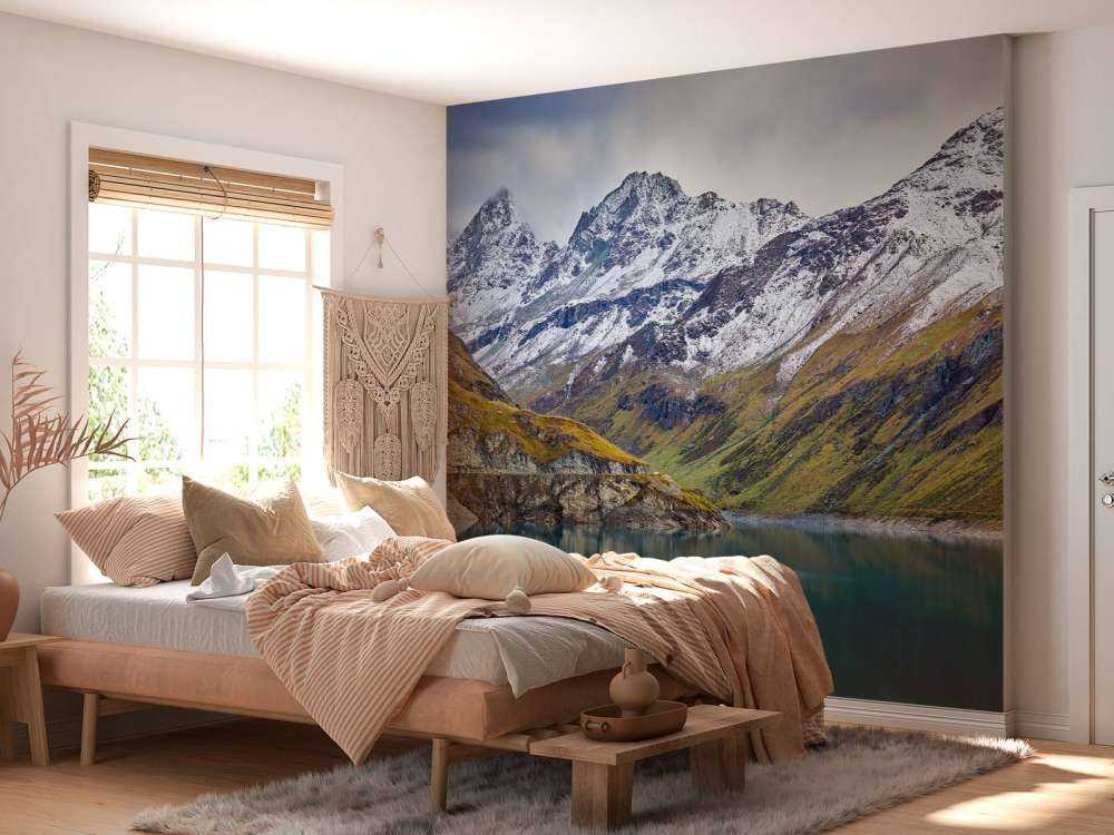 Bergstoppar med snö vid en sjö i bergen