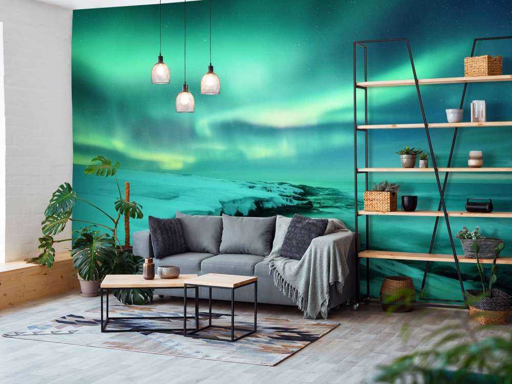 Grønt nordlys over snedækkede klipper