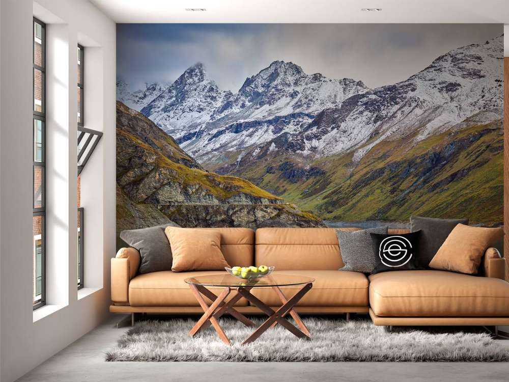 Bergstoppar med snö vid en sjö i bergen