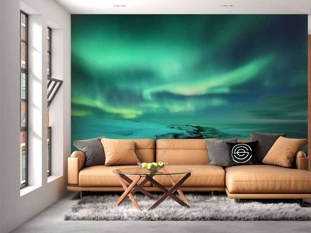 Grønt nordlys over snedækkede klipper